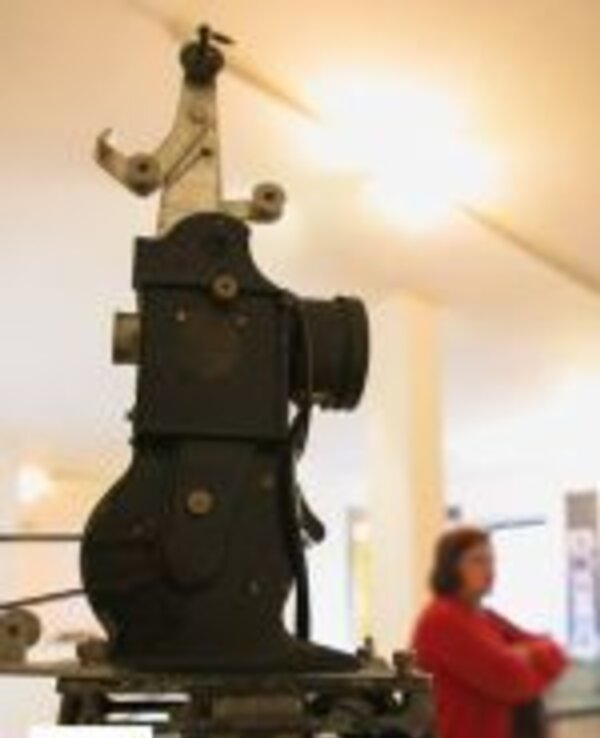 Máquina antiga de costura em exibição, com detalhes mecânicos visíveis.