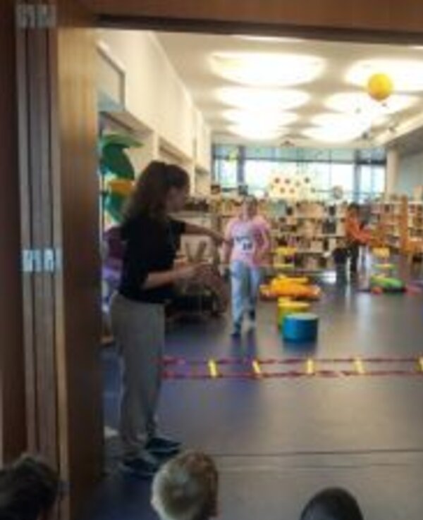 Crianças a participar em atividades lúdicas numa biblioteca escolar.