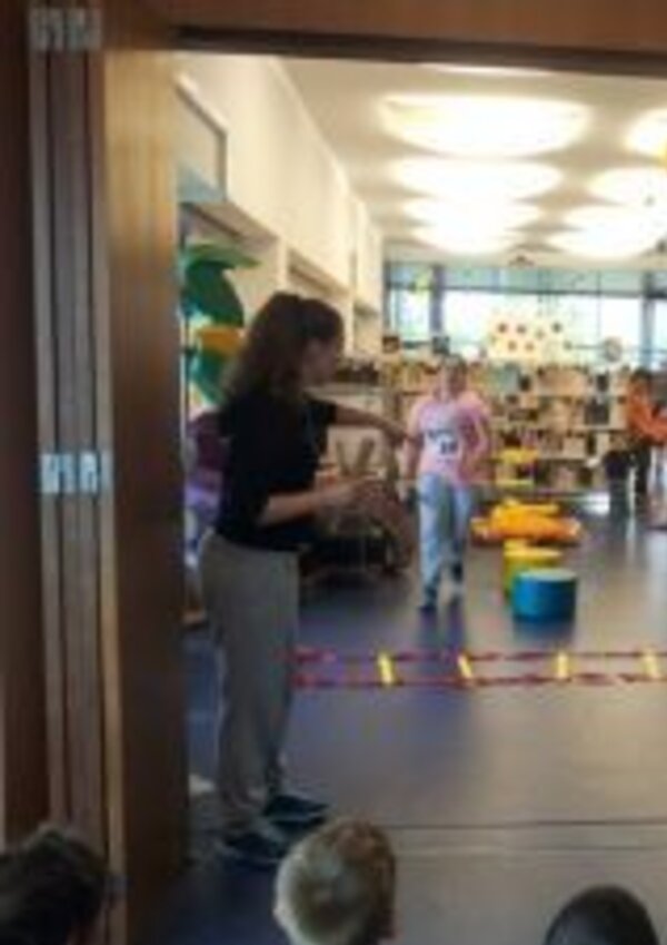 Crianças a participar em atividades lúdicas numa biblioteca escolar.