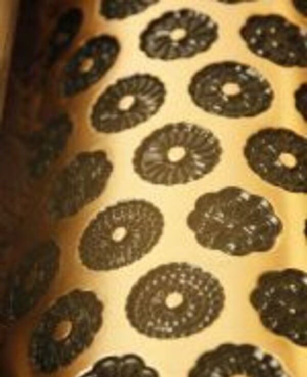 Padrão de formas florais em preto sobre fundo dourado.