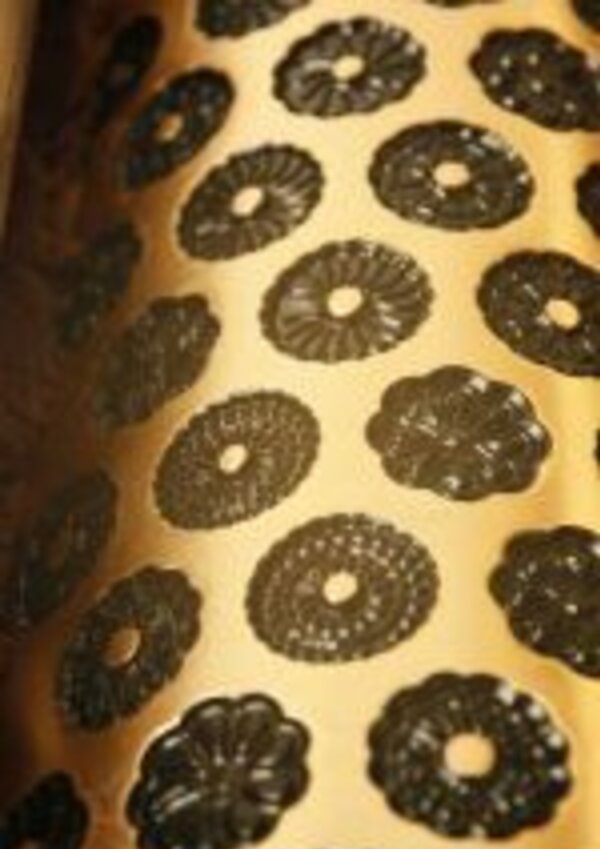 Padrão de formas florais em preto sobre fundo dourado.