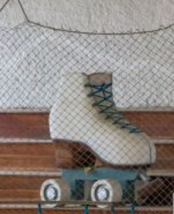 Um patins de rodas suspenso por uma rede, com detalhes em azul e branco.