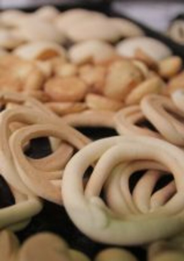 Diversos biscoitos em forma de laço, com diferentes texturas e cores.