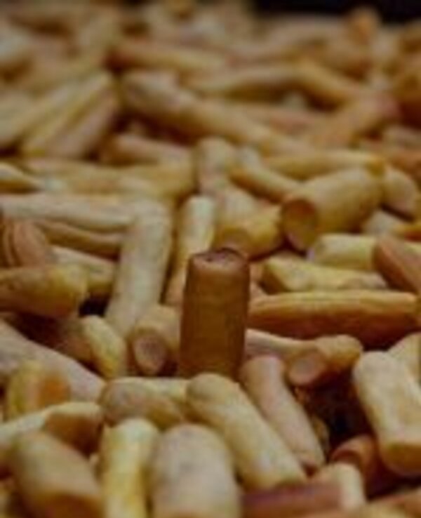 Um monte de biscoitos em forma de palito, com um biscoito mais alto ao centro.