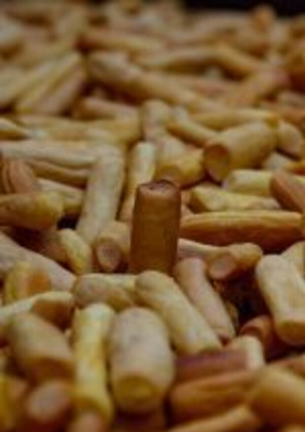 Um monte de biscoitos em forma de palito, com um biscoito mais alto ao centro.