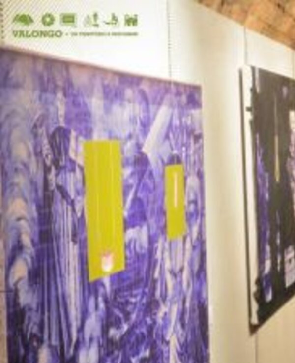 Exposição de arte com quadros em tons de azul e amarelo, em ambiente interior.