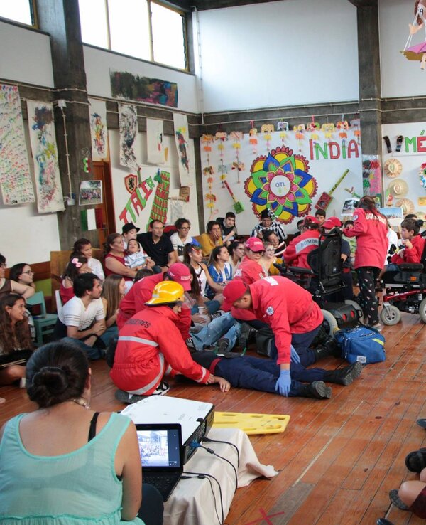 Grupo de pessoas em um evento, com participantes em trajes coloridos e interações.