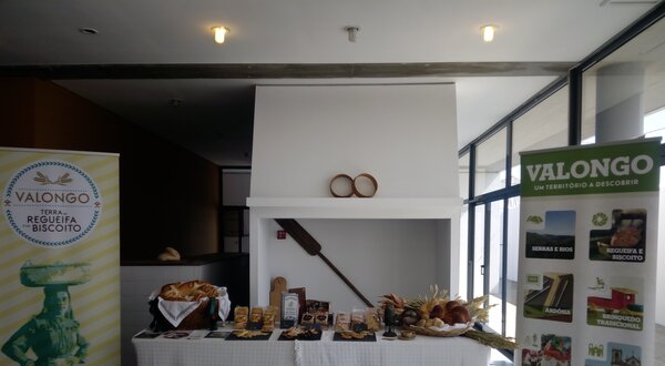 Mesa com produtos regionais de Valongo, incluindo biscoitos e pães.