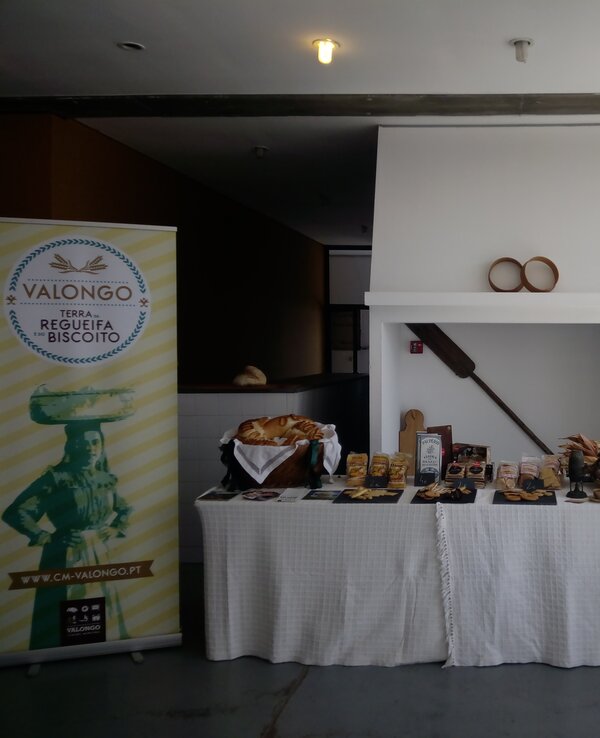 Mesa com produtos regionais de Valongo, incluindo biscoitos e pães.