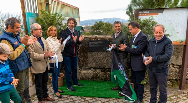 Grupo de pessoas aplaudindo durante a inauguração de uma placa comemorativa.
