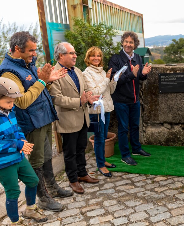 Grupo de pessoas aplaudindo durante a inauguração de uma placa comemorativa.