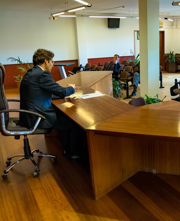 Um orador apresenta-se a uma audiência atenta numa sala de conferências.