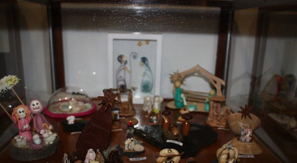 Vitrina com várias figuras decorativas e uma moldura com ilustração.