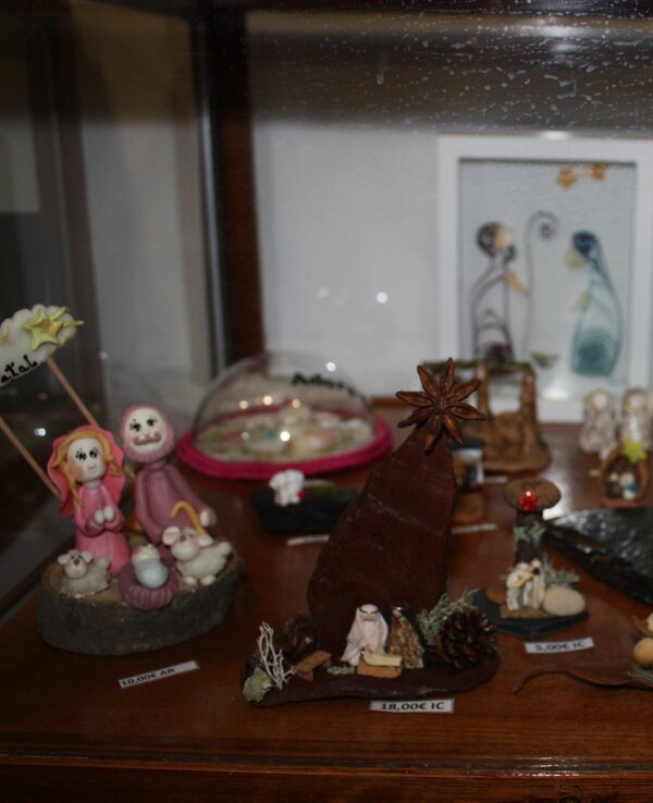 Vitrina com várias figuras decorativas e uma moldura com ilustração.