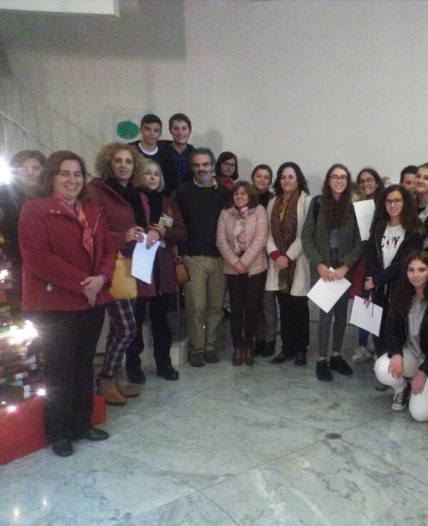 Grupo de pessoas sorridentes posando em um espaço interior, com decoração natalina.