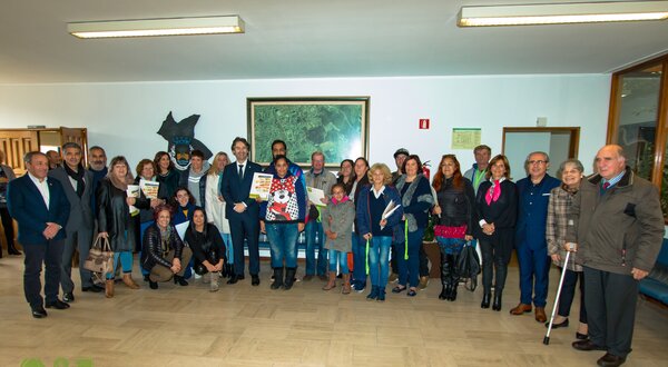 Grupo de pessoas sorridentes reunidas num espaço interior, segurando diplomas.