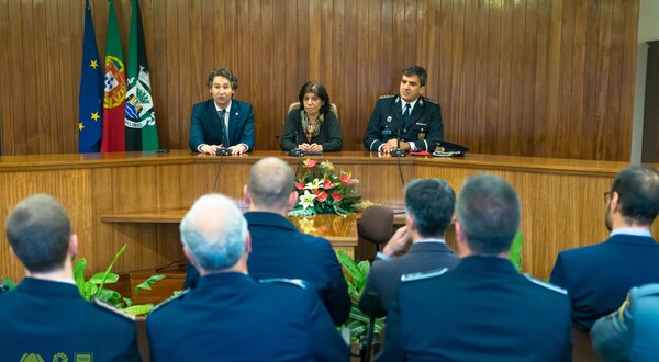 Reunião formal com autoridades e polícias em ambiente institucional.