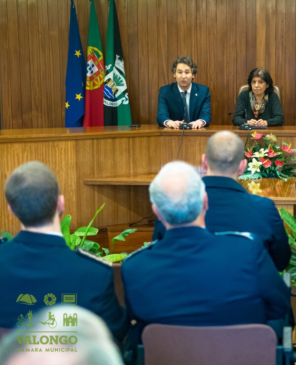 Reunião formal com autoridades e polícias em ambiente institucional.
