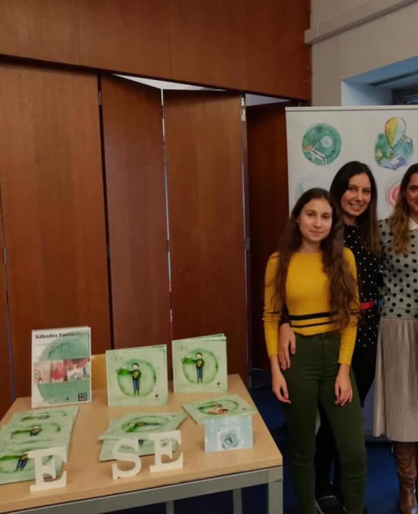 Quatro pessoas posam juntas em frente a uma árvore de Natal decorada.