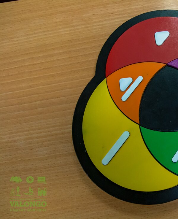 Um jogo de tabuleiro com círculos coloridos e formas brancas.