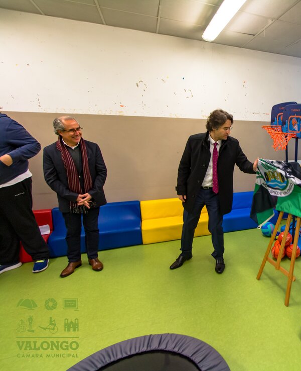 Espaço de lazer com um homem a apresentar atividades desportivas para jovens.