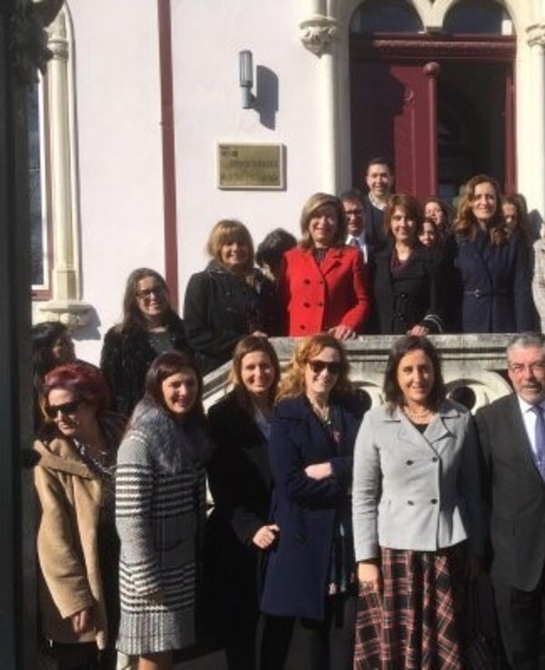 Grupo de pessoas posando em frente a um edifício histórico.
