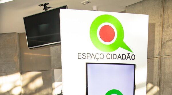 Interior do Espaço Cidadão com computadores e sinalização visível.