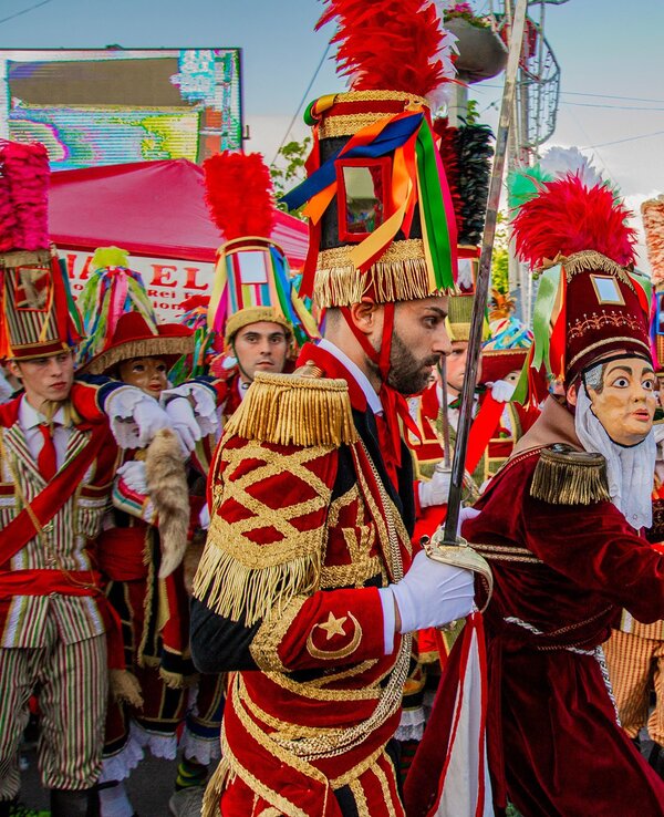 Grupo de pessoas em trajes coloridos e festivos durante uma celebração.