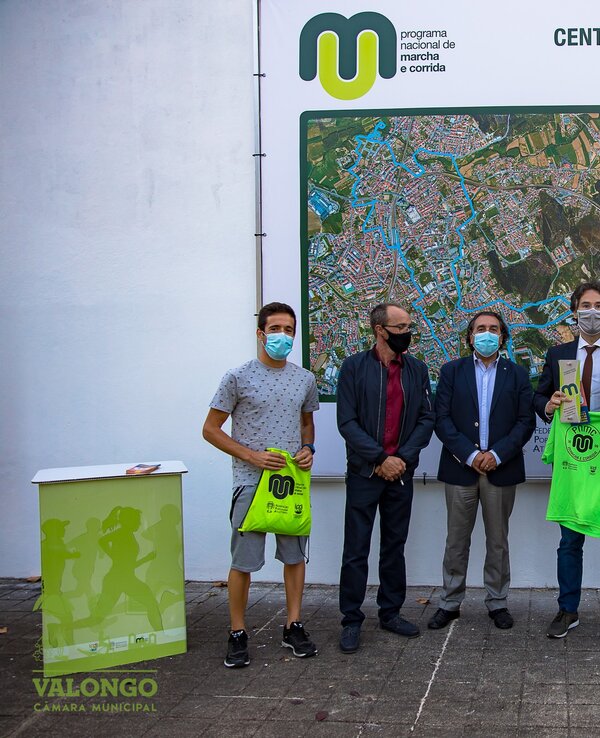 Grupo de pessoas a receber camisetas verdes em evento no Centro Municipal de Marcha.