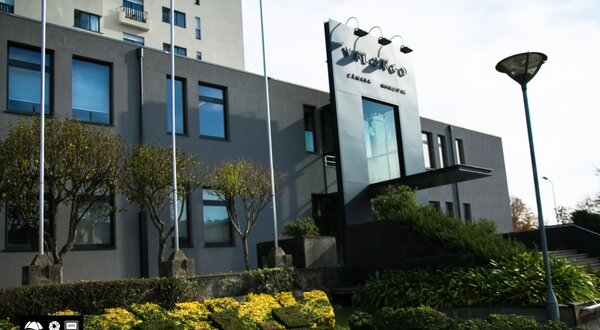 Fachada moderna do edifício Valongo com jardins bem cuidados.