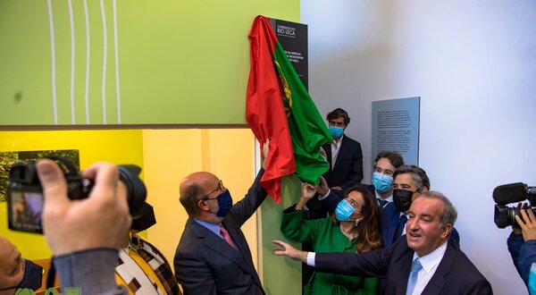 Cerimónia de descerramento de uma placa com a bandeira de Portugal.