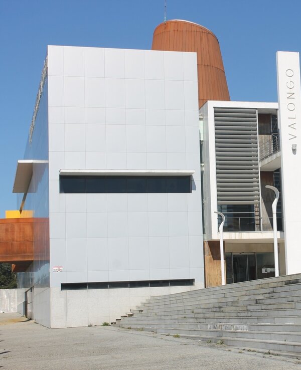 Edifício moderno em Valongo, com escadas e fachada de vidro.