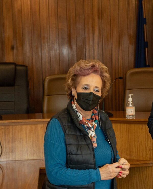 Duas pessoas em um ambiente formal, uma mulher e um homem, conversando.