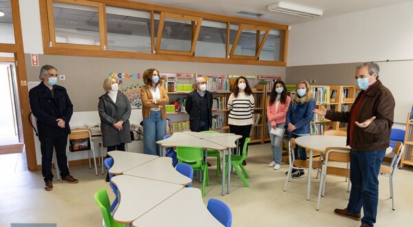Grupo de pessoas em uma sala de aula, ouvindo um orador.