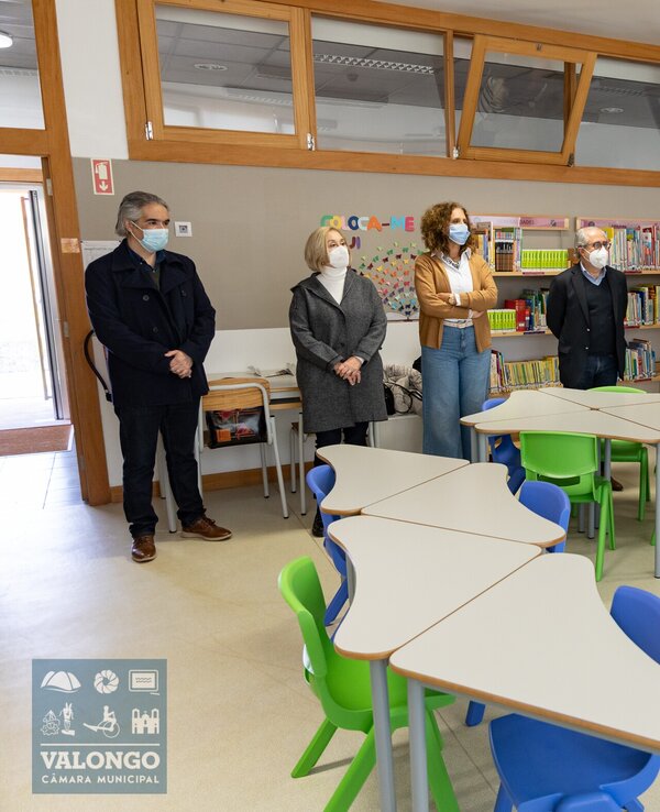 Grupo de pessoas em uma sala de aula, ouvindo um orador.