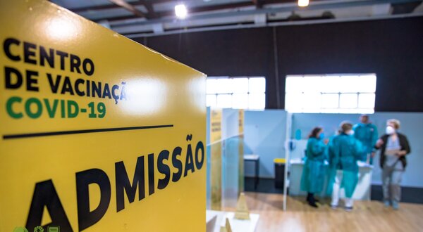 Placa amarela com a palavra 'ADMISSÃO' em um centro de vacinação COVID-19.