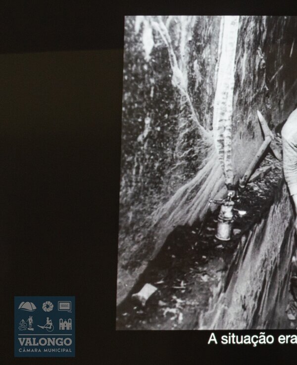 Imagem em preto e branco de trabalhadores em condições difíceis, escavando.