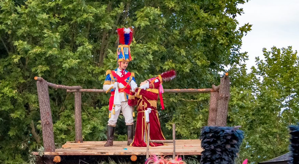 Grupo de pessoas em trajes tradicionais numa celebração ao ar livre.
