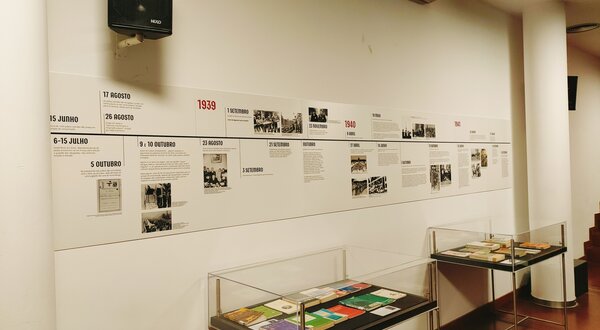 Linha do tempo histórica exposta numa parede, com textos e imagens.