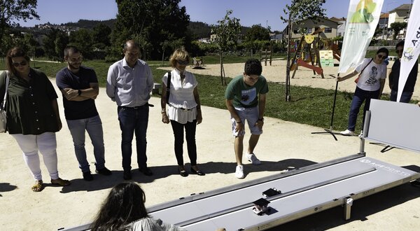 Grupo de pessoas observando uma demonstração de equipamento acessível ao ar livre.