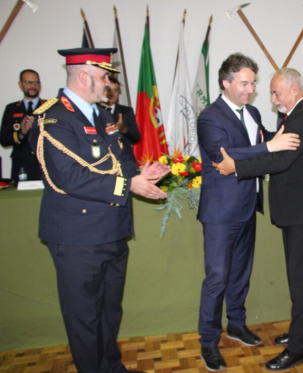 Cerimónia de entrega de prémios com várias pessoas a cumprimentar-se.