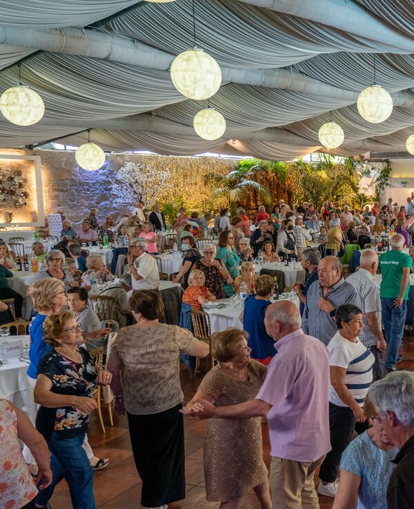 Um grande salão com muitas pessoas idosas a dançar e socializar.