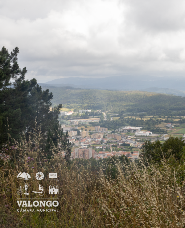Vista panorâmica de Valongo com montanhas e nuvens ao fundo.