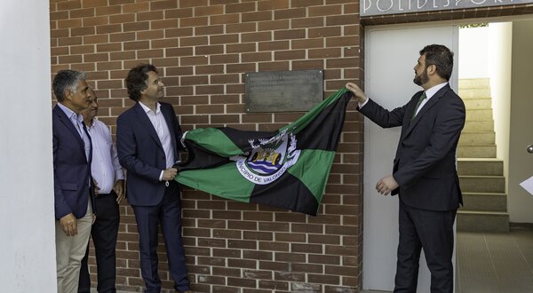 Cerimónia de descerramento de placa com uma bandeira em destaque.