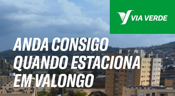 Homem de braços cruzados em frente a edifícios e parquímetros em Valongo.