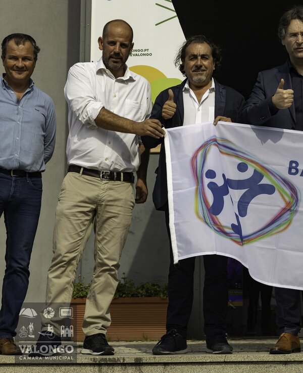 Grupo de pessoas segurando a bandeira da Ética em evento público.