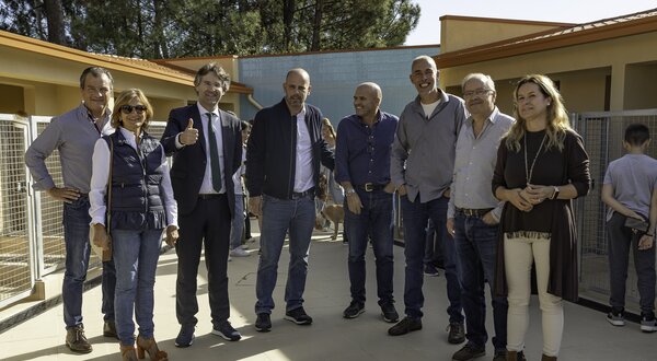 Grupo de pessoas em um espaço exterior, algumas com gestos de aprovação.