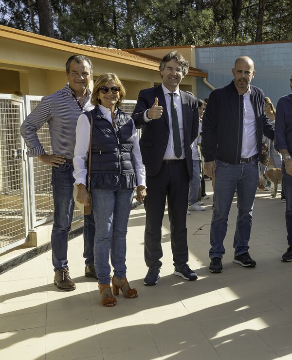 Grupo de pessoas em um espaço exterior, algumas com gestos de aprovação.