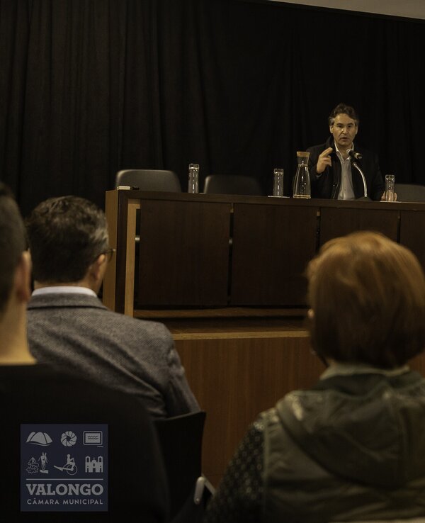 Palestra sobre sustentabilidade com orador e público atento.