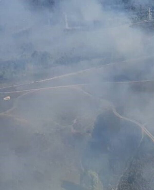 Vista aérea de um incêndio florestal com fumo a cobrir a paisagem.